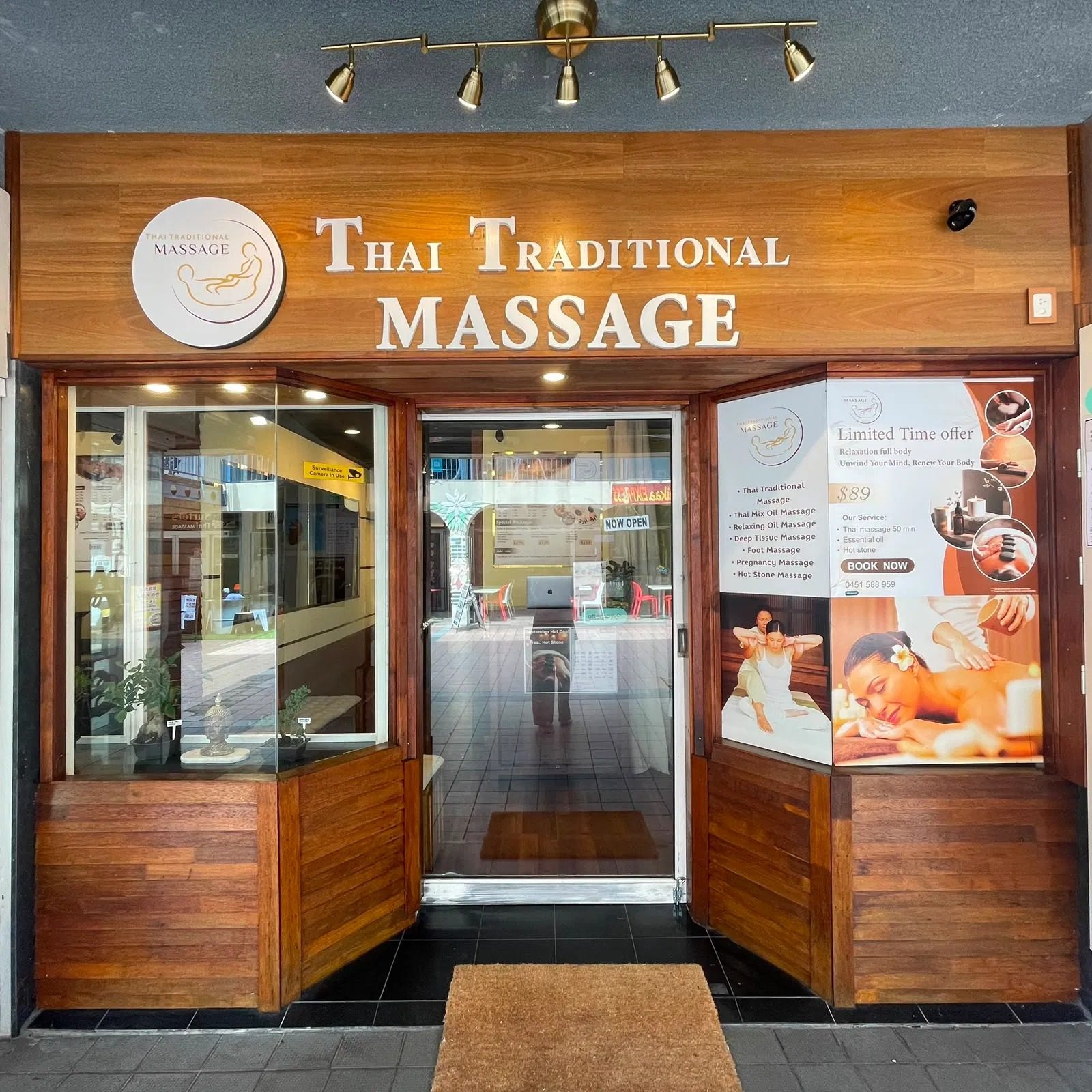 The Thai Traditional Massage shopfront by day, with the roundel logo, timber fascia and NOW OPEN sign